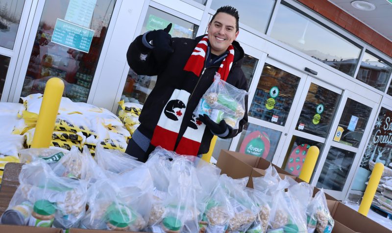 Can Man Dan standing over a big food bank donation in front of Southbrook Sobeys. Weather conditions are clear.