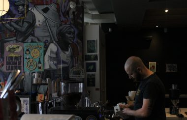 Gabriel Sims-Fewer owner of the Anarchist Cafe pouring milk into a coffee