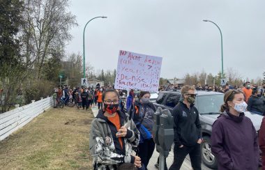 Dans une manifestation, une femme tient une pancarte où est écrit en anglais «ma tante Denise Boucher est morte à l'âge de 7 ans».