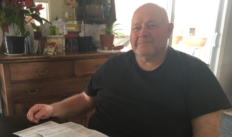 Frosty Hollow resident Terry Greene sits at his dining room table with his Tantramar tax file. Photo: Erica Butler