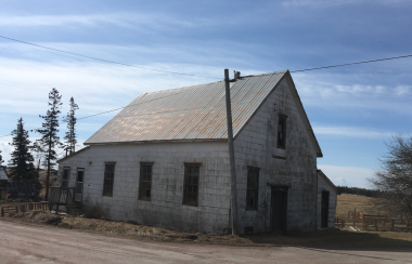 An old building with rusty metal roof in the countryside.