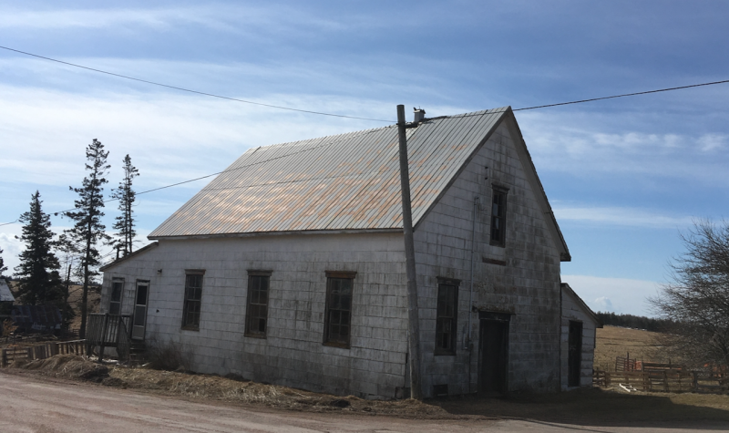 An old building with rusty metal roof in the countryside.