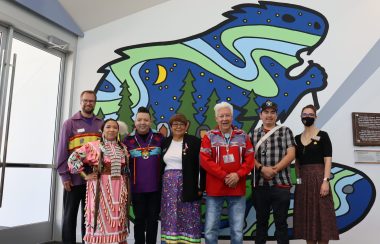 Image shows members of the Mural ceremony standing in front of new mural