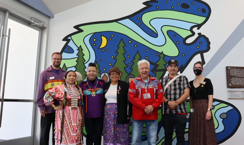 Image shows members of the Mural ceremony standing in front of new mural