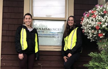 Pictured is Alex and Léa standing in front of Renaissance Lac-Brome's office with its business sign serving as the background.