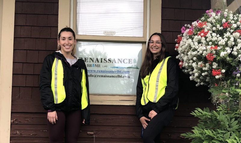 Pictured is Alex and Léa standing in front of Renaissance Lac-Brome's office with its business sign serving as the background.