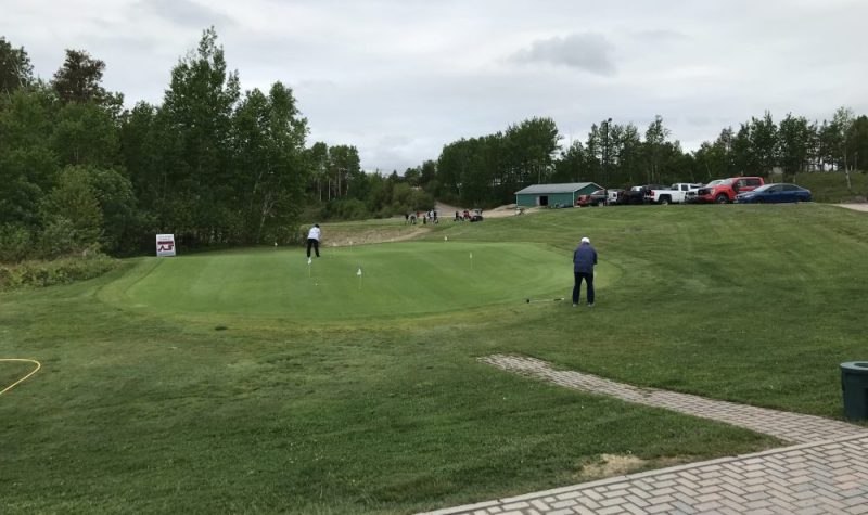 Des joueurs de golf lors d'un entraînement de putting près du vert