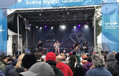 Des musiciens sur scène en prestation devant une foule attentive