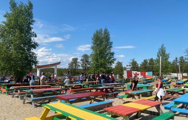 Des dizaines de tables de pique-nique multicolores sont aménagées sur le site du festival Folk on the Rocks.