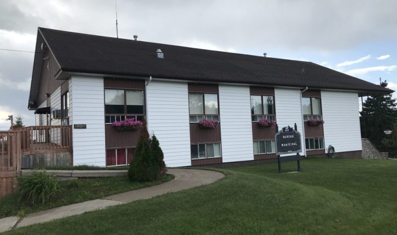 Bâtiment muni d'un toit noir avec des fenêtres séparées de mur blanc