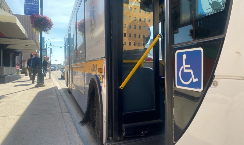 Un autobus des tranports publics de la municipalité de Yellowknife, avec à l'avant plan une vignette indiquant l'accessibilité aux personnes à mobilité réduite