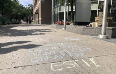 A chalk message in French decries Quebec's welfare travel limits.