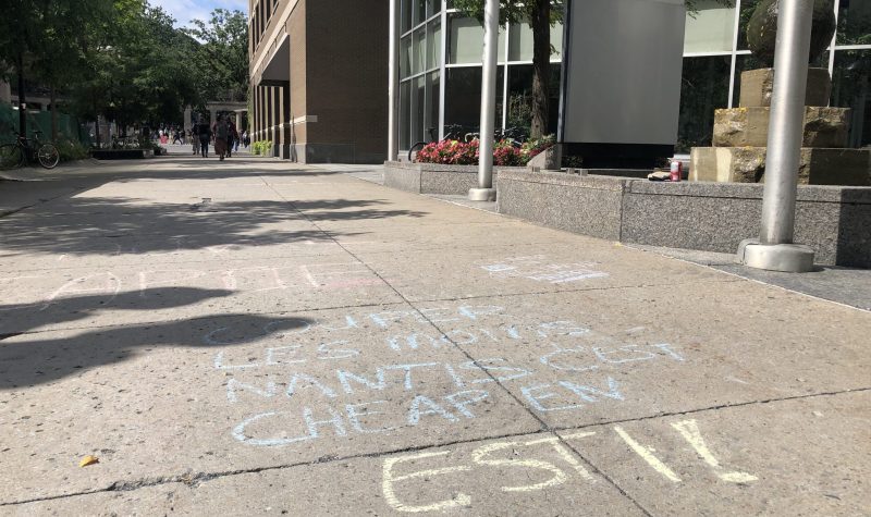 A chalk message in French decries Quebec's welfare travel limits.