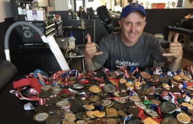 Phil Brown is seen sitting with around 100 medals, as he has been competing at the Special Olympics at the age of 18.