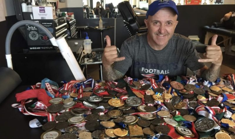 Phil Brown is seen sitting with around 100 medals, as he has been competing at the Special Olympics at the age of 18.