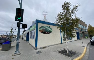 À l'angle d'une rue, un édifice sur lequel sont peintes des aurores boréales.