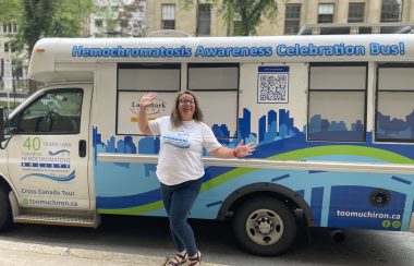 Photo of Liz Charyna, standing in front of her customized Elsie The Bus to raise awareness on hemochromatosis.