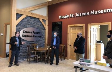 Quatre hommes debout dans un centre de tourisme au Musée de St-Joseph