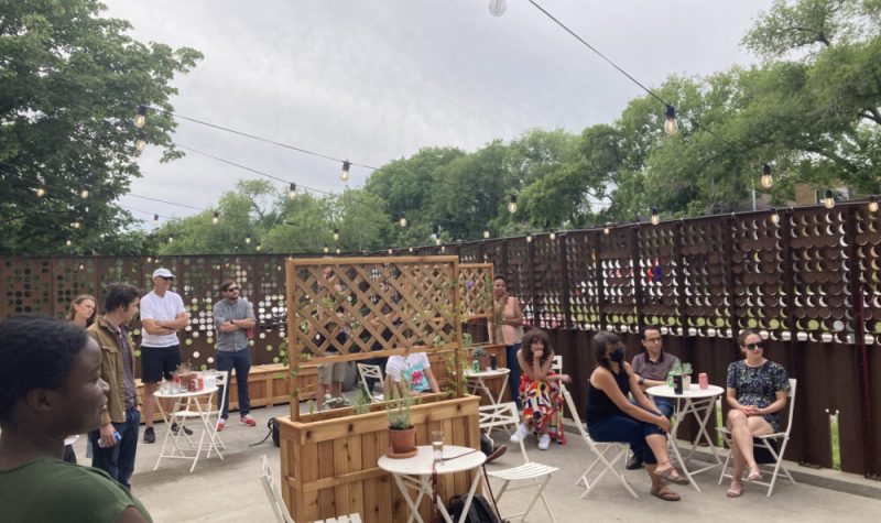 Soirée privée de l’inauguration du « Petit Patio du TCM ». Une douzaine d'invités sont assis ou debout pour écouter le discours de Ginette Caron, l'ancienne directrice administrative du TCM (hors champ).