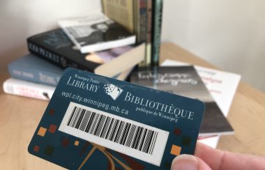 Une carte de bibliothèque devant une pile de livres sur une table.