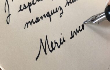 Une phrase écrite en cursive avec une plume trempée dans de l'ancre.