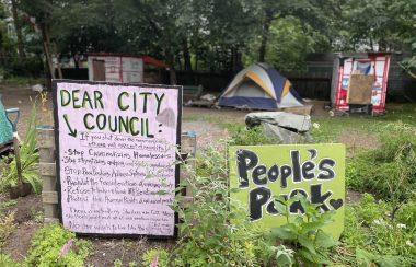 Meagher Park with signs and encampments for the unhoused.