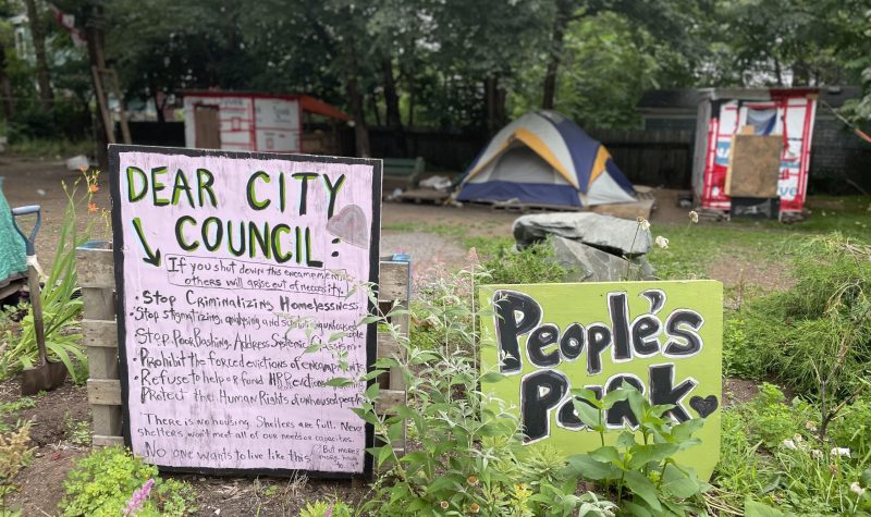 Meagher Park with signs and encampments for the unhoused.