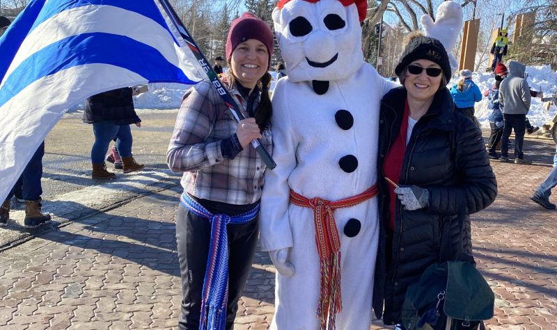 Le carnaval bonhomme, un personnage en forme de bonhomme de neige accueille les invités avec le drapeau franco-albertain. . venu