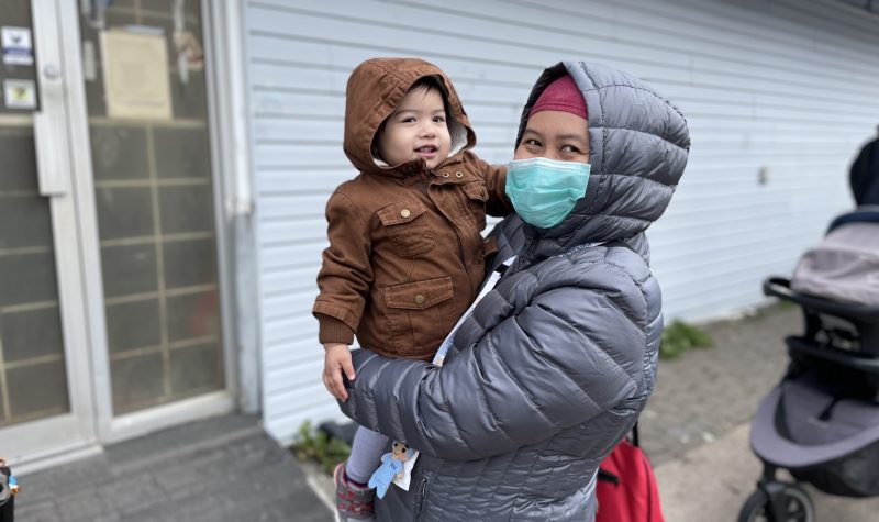 A mother and her infant child standing in line for a coat drive at Parkers Street food and furniture bank.