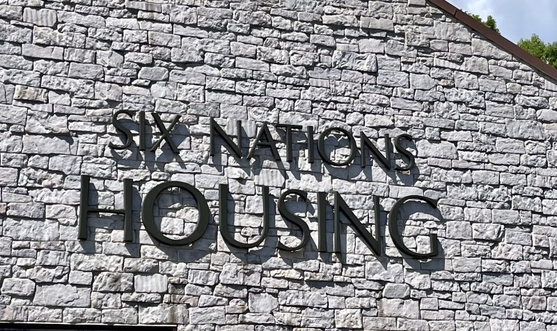 Exterior of the Six Nations Housing building grey brick with black lettering.