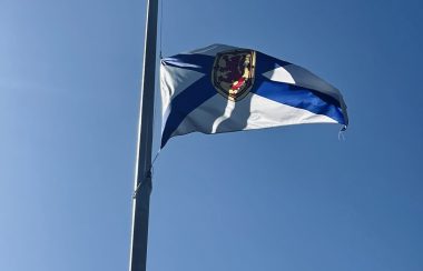 Photo of the Nova Scotia flag with clear blue skies.
