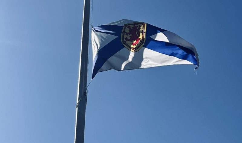 Photo of the Nova Scotia flag with clear blue skies.