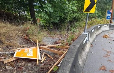 A shattered orange NDP campaign sign at the side of the road