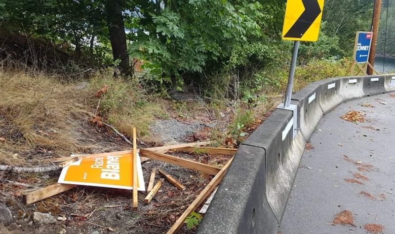 A shattered orange NDP campaign sign at the side of the road