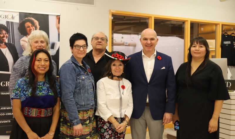 Minister Randy Boissonnault, Joanne Pompana, the Director of the Red Road Healing Society, and other dignitaries at the announcement celebration on November 3rd. They are all standing in a line, with the shortest at the front. Photo was taken indoors.