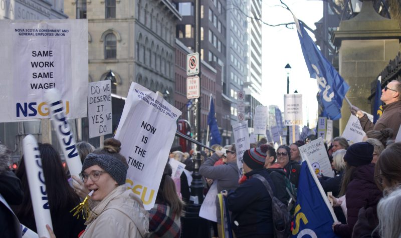 About 100 people holding signs that say same work equals same pay. They are holding signs with NSGEU, in a strike infront of the legislature in Halifax one week ago.