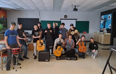 Des élèves dans une école tiennent en main des instruments de musique qu'ils ont reçu en dons