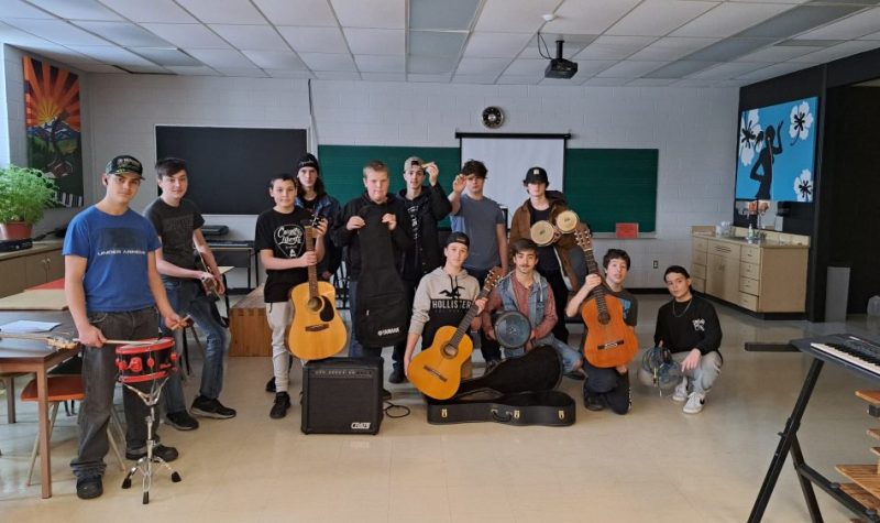 Des élèves dans une école tiennent en main des instruments de musique qu'ils ont reçu en dons