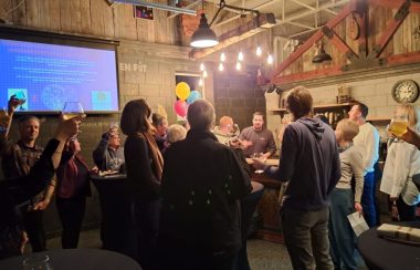 Un foule porte un toast à l'intérieur d'une microbrasserie