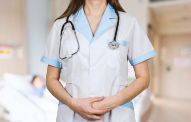 Une infirmière en tenue blanche avec un stétoscope autour du coup