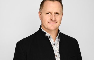 A man in suit jacket, corporate portrait style.