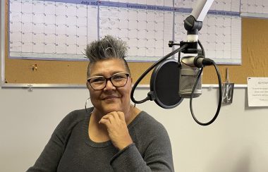 A woman sits at microphone in CKRZ FM station