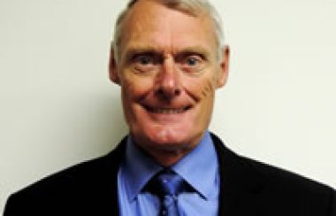 A headshot of Clarendon Mayor John Armstrong, wearing a black suit with a blue shirt.