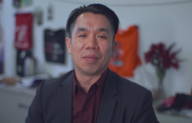 John Su is seen in a professional headshot against a blurred background