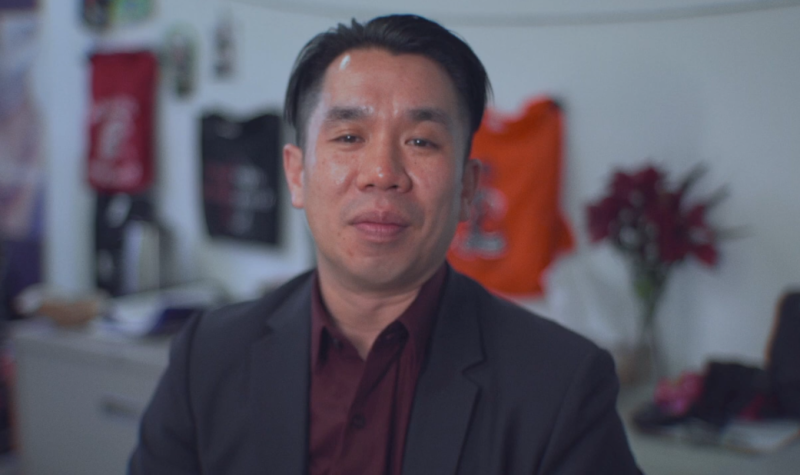 John Su is seen in a professional headshot against a blurred background