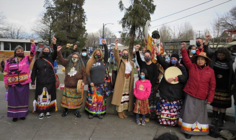 An outdoor group photo in Vancouver of Elder and organizer Kat Norris and other women gather at Grandview Park with ribbon skirts