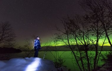 Image shows boy gazing at the northern light (Photo Credits - Louis Iron