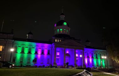 Kingston City Hall lit up purple and green