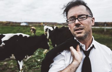 L'auteur-compositeur-interprète Keith Kouna dans un champ de vache