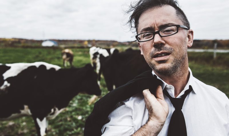 L'auteur-compositeur-interprète Keith Kouna dans un champ de vache
